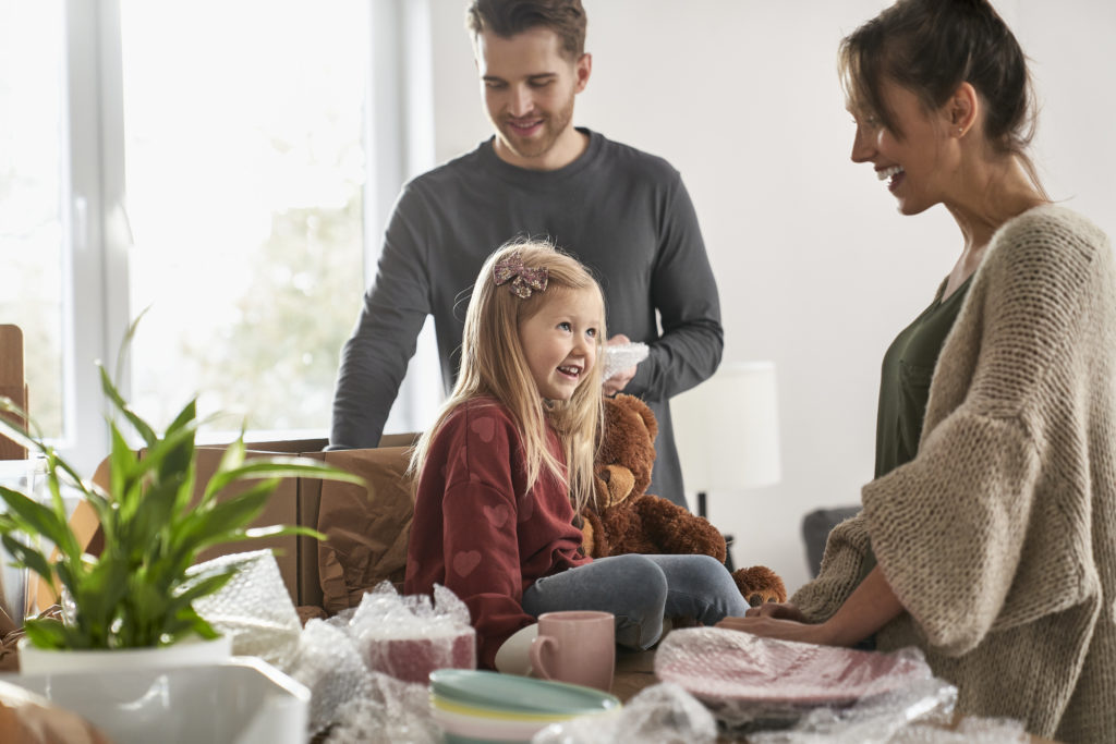 Caucasian family packing kitchen stuff in new house