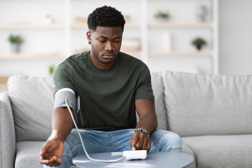 African american guy checking blood pressure, health concerns concept